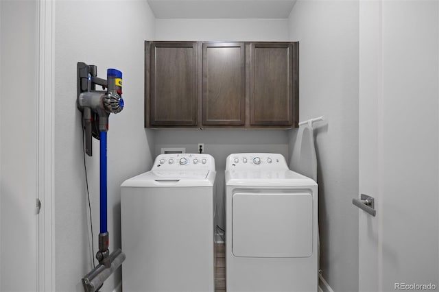 laundry area with independent washer and dryer and cabinets