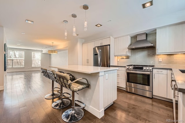 1840 Irving St, Denver, CO 80204 - kitchen featuring stainless steel appliances, wall chimney exhaust hood, modern cabinets, and decorative backsplash