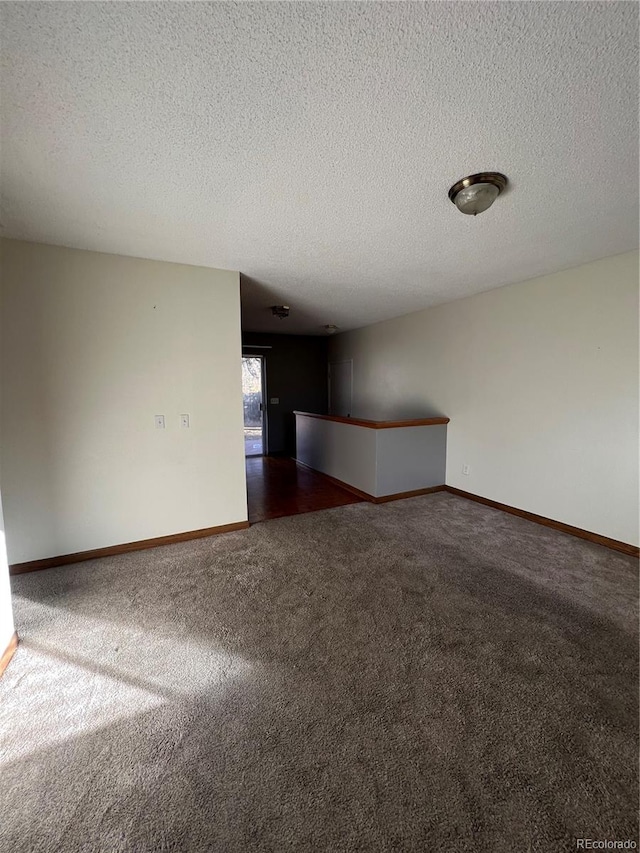 carpeted spare room featuring a textured ceiling