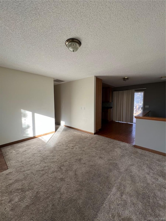 carpeted empty room with a textured ceiling