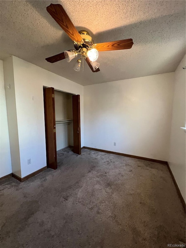 unfurnished bedroom featuring dark colored carpet, ceiling fan, a textured ceiling, and a closet