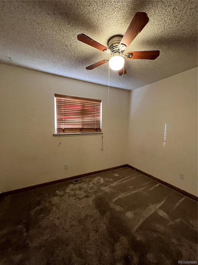 carpeted spare room featuring ceiling fan and a textured ceiling