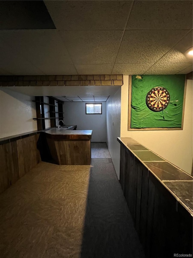 bar featuring a paneled ceiling and carpet flooring