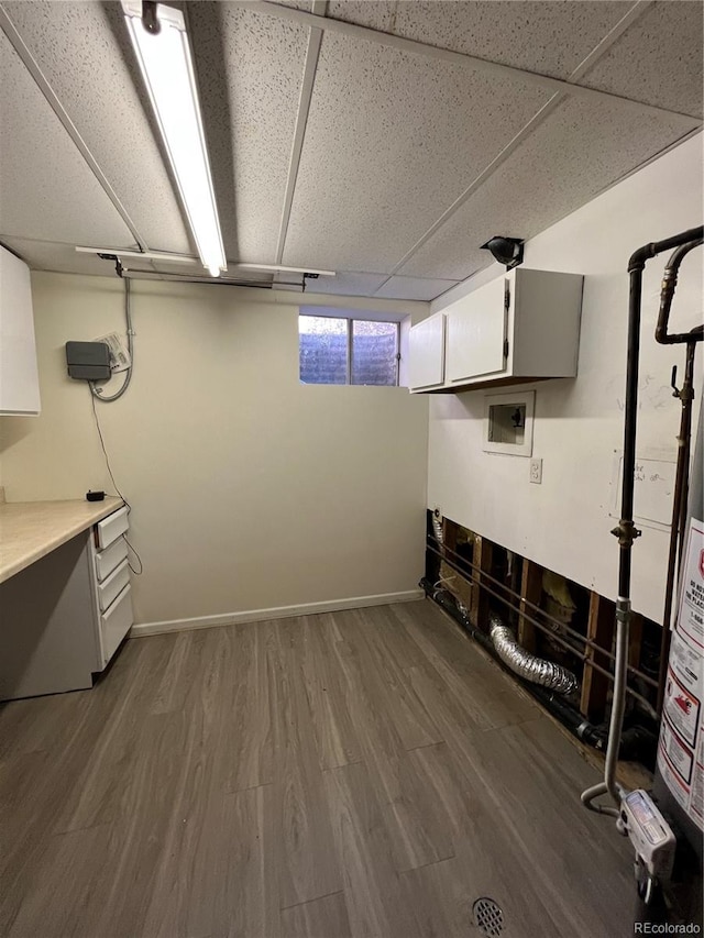 basement featuring dark hardwood / wood-style flooring and a drop ceiling