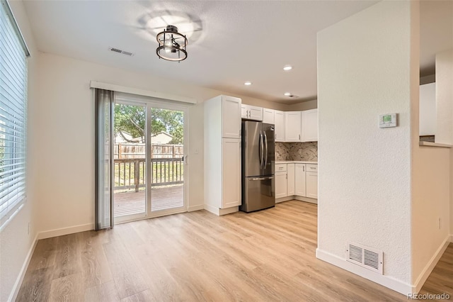 1272 Bluebird St, Brighton, CO 80601 - kitchen featuring freestanding refrigerator, light wood-style flooring, white cabinets, light countertops, and recessed lighting