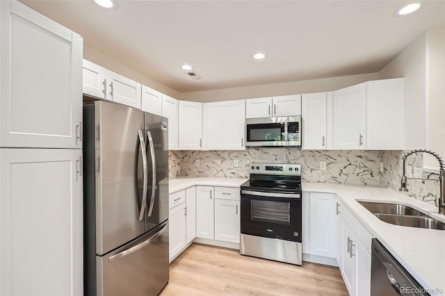 1272 Bluebird St, Brighton, CO 80601 - kitchen featuring appliances with stainless steel finishes, white cabinets, light countertops, decorative backsplash, and recessed lighting