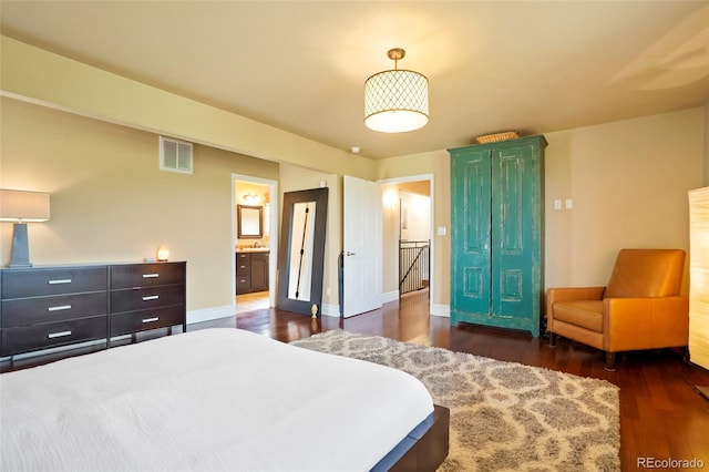 bedroom with dark hardwood / wood-style flooring and ensuite bathroom