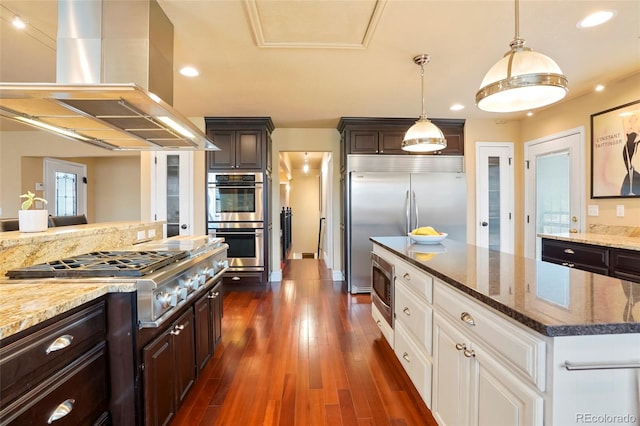 kitchen with island exhaust hood, dark brown cabinetry, dark wood-type flooring, built in appliances, and white cabinets