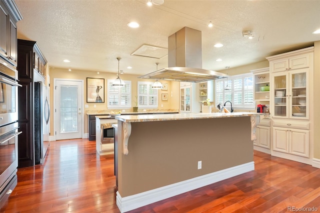 kitchen featuring a spacious island, a textured ceiling, and dark wood-type flooring