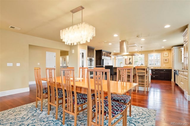 dining space with dark hardwood / wood-style flooring and an inviting chandelier