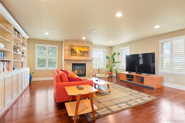 living room featuring a fireplace, a textured ceiling, and dark hardwood / wood-style flooring