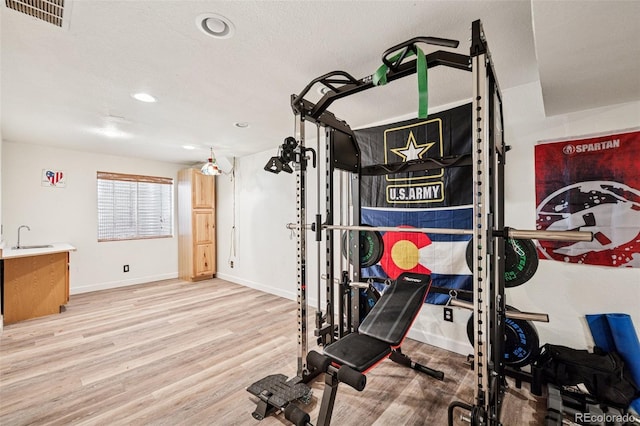3904 Breaking Dawn St, Colorado Springs, CO 80925 - workout room with wood finished floors, a sink, baseboards, and recessed lighting
