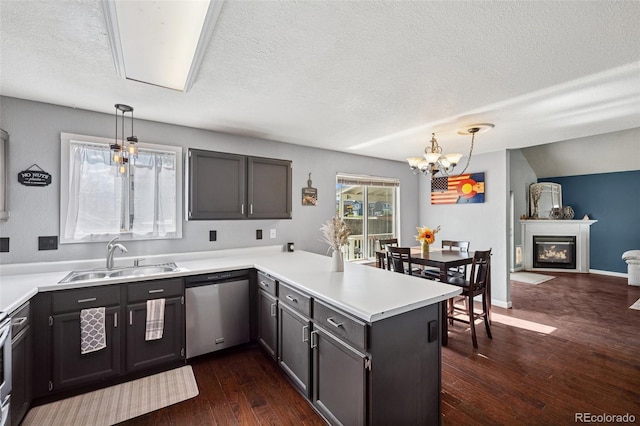 3904 Breaking Dawn St, Colorado Springs, CO 80925 - kitchen with a sink, stainless steel dishwasher, a peninsula, a chandelier, and a textured ceiling