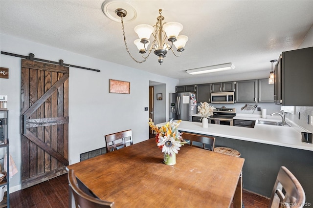 3904 Breaking Dawn St, Colorado Springs, CO 80925 - dining space with dark wood finished floors, a barn door, and a chandelier