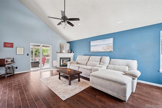 3904 Breaking Dawn St, Colorado Springs, CO 80925 - living area with high vaulted ceiling, a ceiling fan, a glass covered fireplace, wood finished floors, and baseboards