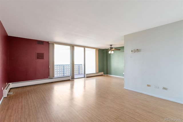 spare room featuring a wall of windows, ceiling fan, light hardwood / wood-style flooring, and a baseboard radiator