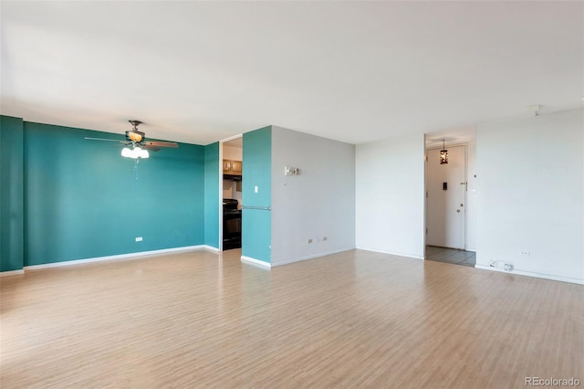 empty room with baseboards, a ceiling fan, and wood finished floors