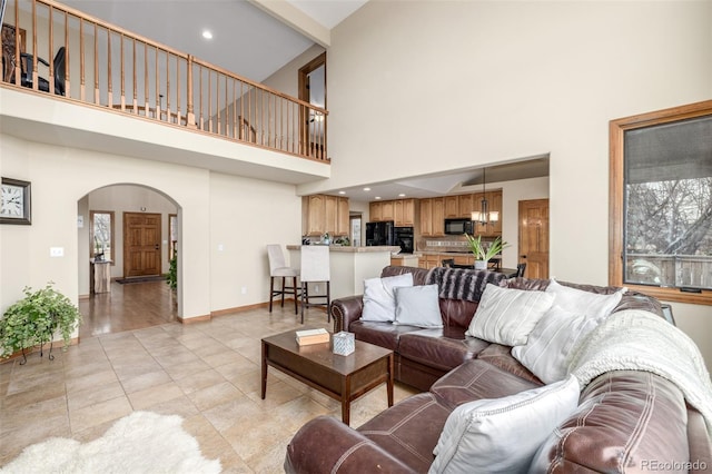 living room with beamed ceiling, plenty of natural light, a high ceiling, and light tile patterned floors