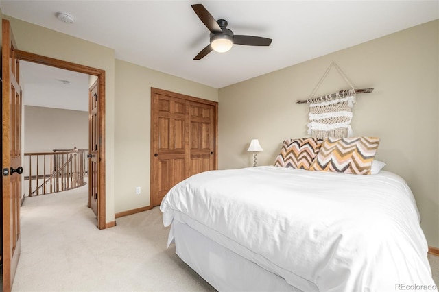 bedroom with ceiling fan, a closet, and light carpet