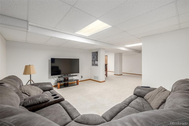 living room featuring carpet and a paneled ceiling