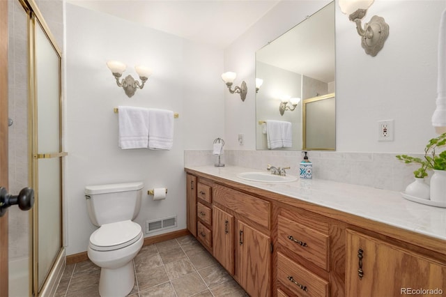 bathroom featuring vanity, tile patterned floors, toilet, and walk in shower