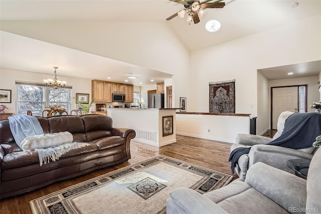 living area with high vaulted ceiling, ceiling fan with notable chandelier, baseboards, and wood finished floors