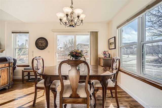 dining area featuring light wood-style floors, baseboards, and an inviting chandelier