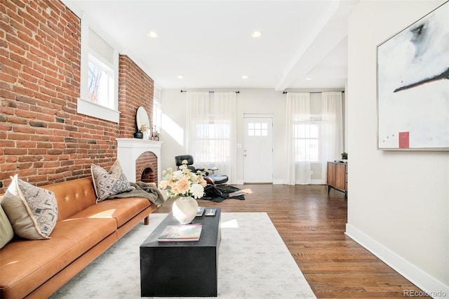 living area featuring a fireplace, recessed lighting, brick wall, wood finished floors, and baseboards