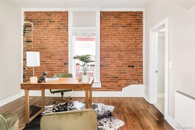 office featuring brick wall, ornamental molding, wood finished floors, and baseboards