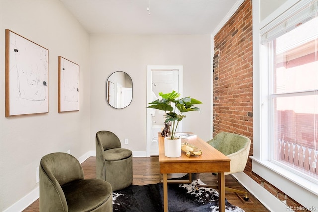 home office featuring brick wall, wood finished floors, and baseboards