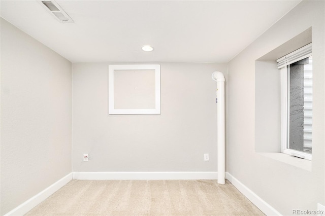 spare room with visible vents, light carpet, and baseboards