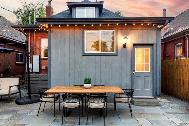 view of outbuilding with fence and outdoor dining space