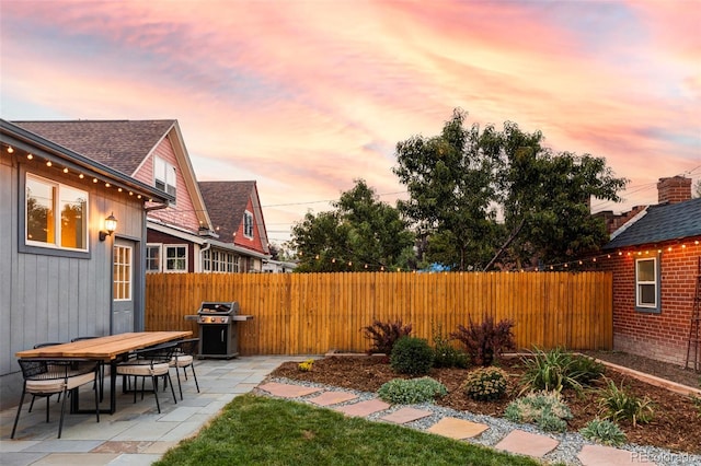 view of patio featuring a grill and fence