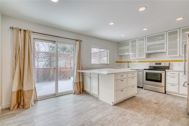 kitchen featuring light countertops, appliances with stainless steel finishes, glass insert cabinets, and white cabinetry