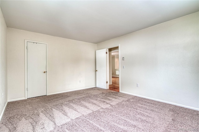 empty room with baseboards and carpet flooring