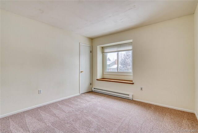 empty room featuring carpet, a baseboard radiator, and baseboards