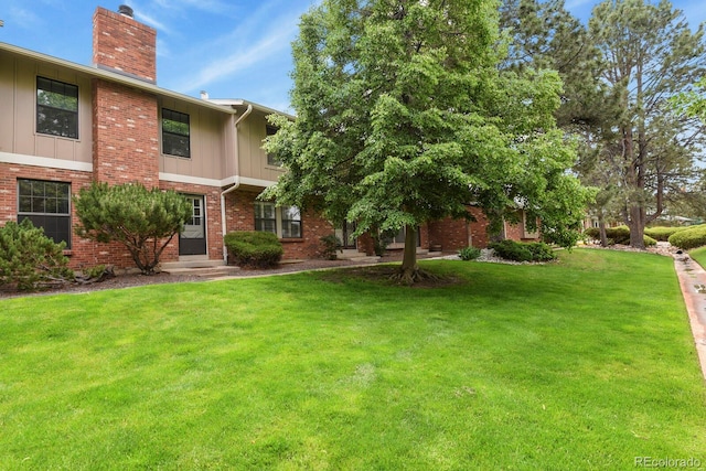 10310 E Jewell Ave Unit 55, Aurora, CO 80247 - view of front of house with a chimney, a front lawn, board and batten siding, and brick siding