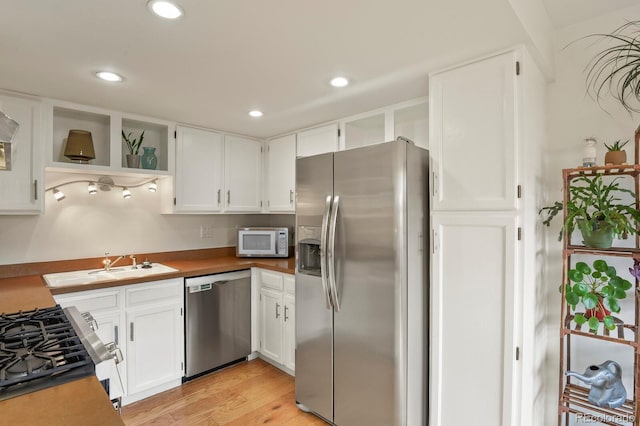 10310 E Jewell Ave Unit 55, Aurora, CO 80247 - kitchen with appliances with stainless steel finishes, open shelves, white cabinetry, light wood-type flooring, and recessed lighting
