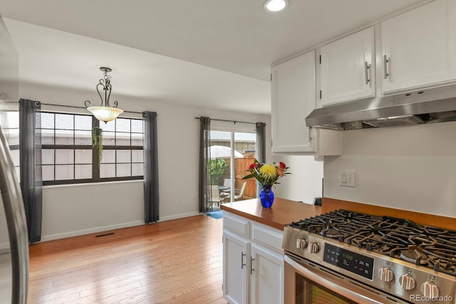 10310 E Jewell Ave Unit 55, Aurora, CO 80247 - kitchen featuring stainless steel range with gas stovetop, under cabinet range hood, white cabinetry, light wood finished floors, and hanging light fixtures