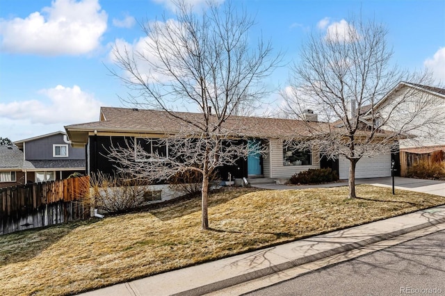 single story home featuring a garage, fence, driveway, a chimney, and a front yard