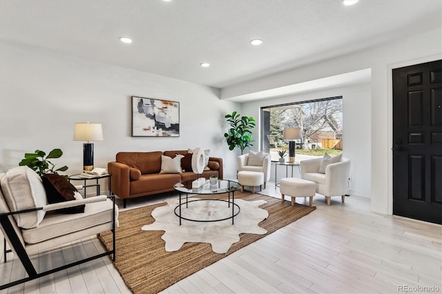 living area featuring light wood-type flooring and recessed lighting