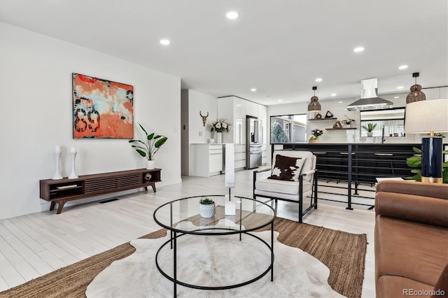 living area with light wood-type flooring and recessed lighting