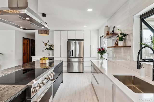 kitchen with a sink, modern cabinets, stainless steel fridge, range, and extractor fan