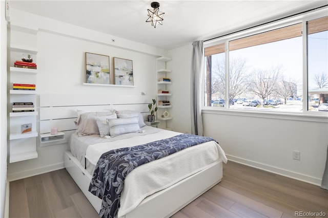1922 E 18th Ave, Denver, CO 80206 - bedroom with multiple windows, wood finished floors, and baseboards
