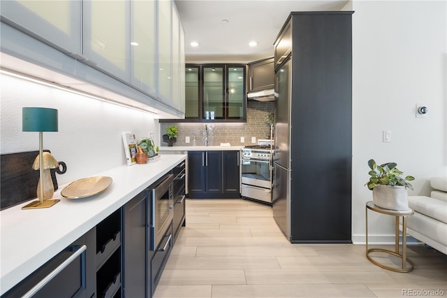1922 E 18th Ave, Denver, CO 80206 - kitchen featuring stainless steel appliances, light countertops, decorative backsplash, a sink, and light wood finished floors