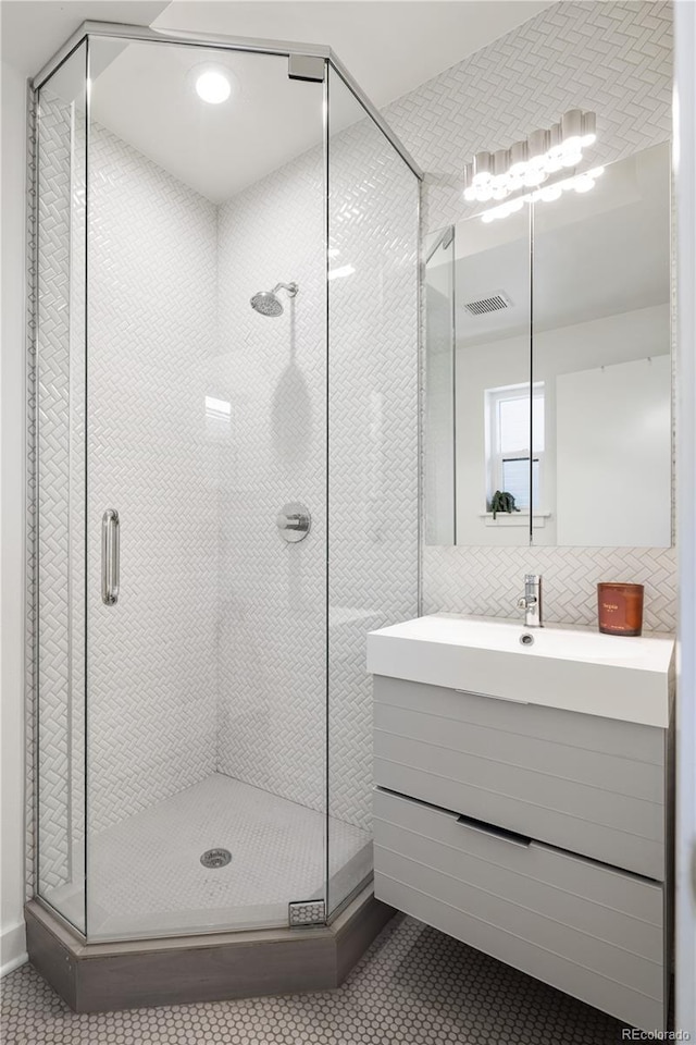 1922 E 18th Ave, Denver, CO 80206 - bathroom featuring tile patterned flooring, a stall shower, vanity, tile walls, and decorative backsplash
