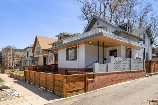 1922 E 18th Ave, Denver, CO 80206 - view of front facade featuring brick siding, a fenced front yard, and a porch
