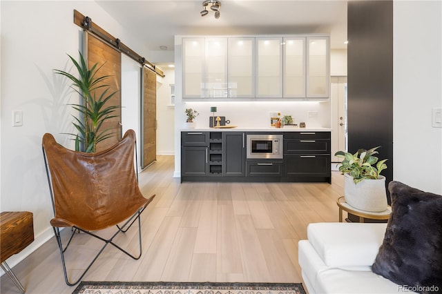 1922 E 18th Ave, Denver, CO 80206 - indoor dry bar featuring stainless steel microwave, a barn door, light wood-style floors, and baseboards