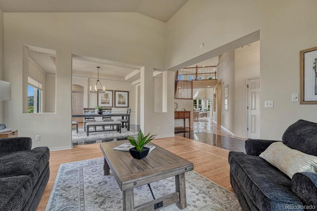 580 Eagle Nest Ct, Golden, CO 80401 - living area with light wood-type flooring, healthy amount of natural light, a chandelier, baseboards, and vaulted ceiling