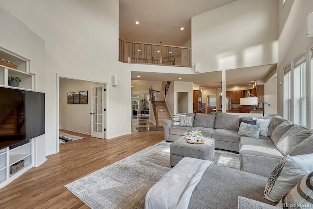 580 Eagle Nest Ct, Golden, CO 80401 - living room with wood finished floors, a high ceiling, stairs, and baseboards